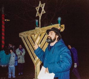 Moshe Gresser and a large wooden menorah.