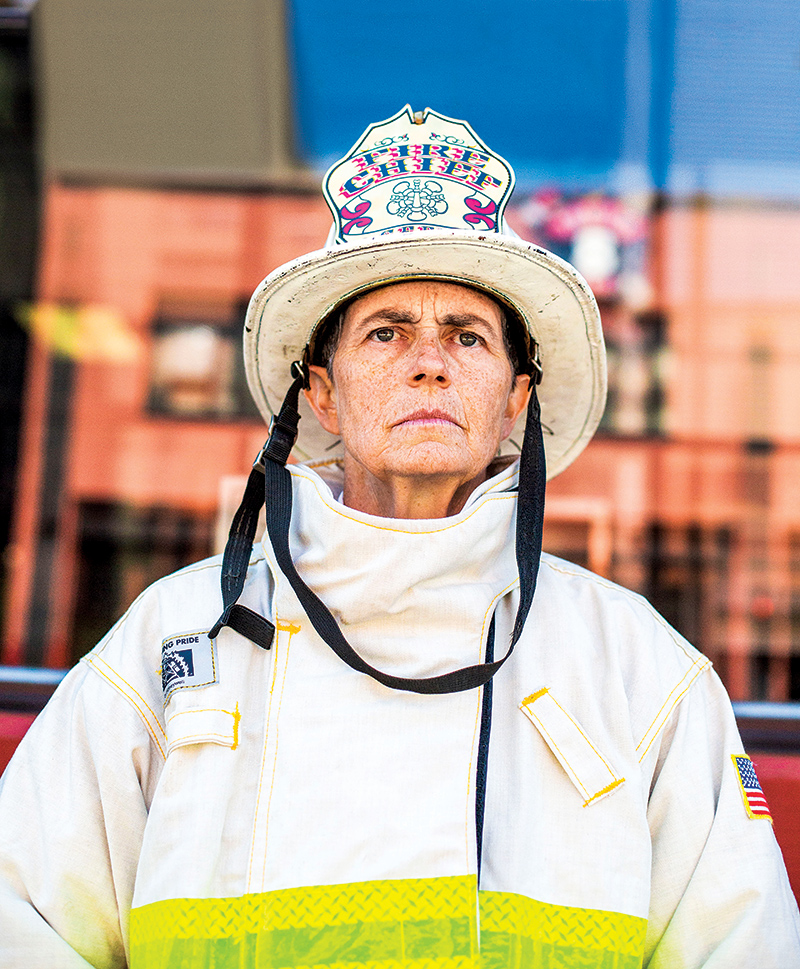 Jeanine Nicholson ’86 wearing her firefighting gear and fire chief hat