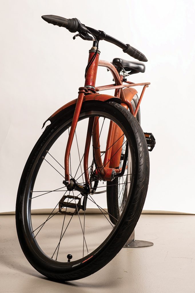 Front view of a rusty orange bike with flame details