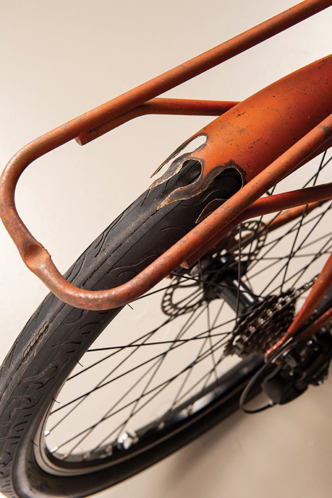 Close up of a rusty orange bike with flame details