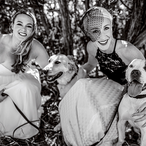 Emmi and Jesse in wedding attire with two of their dogs
