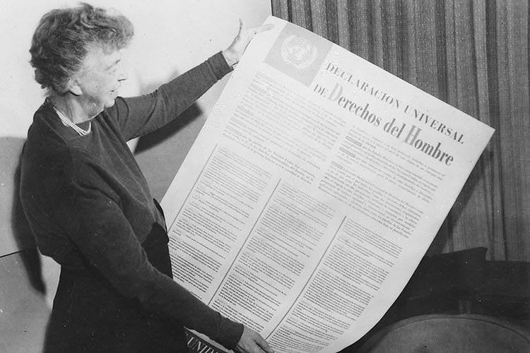 Eleanor Roosevelt holds up a copy of the Universal Declaration of Human Rights in Spanish.