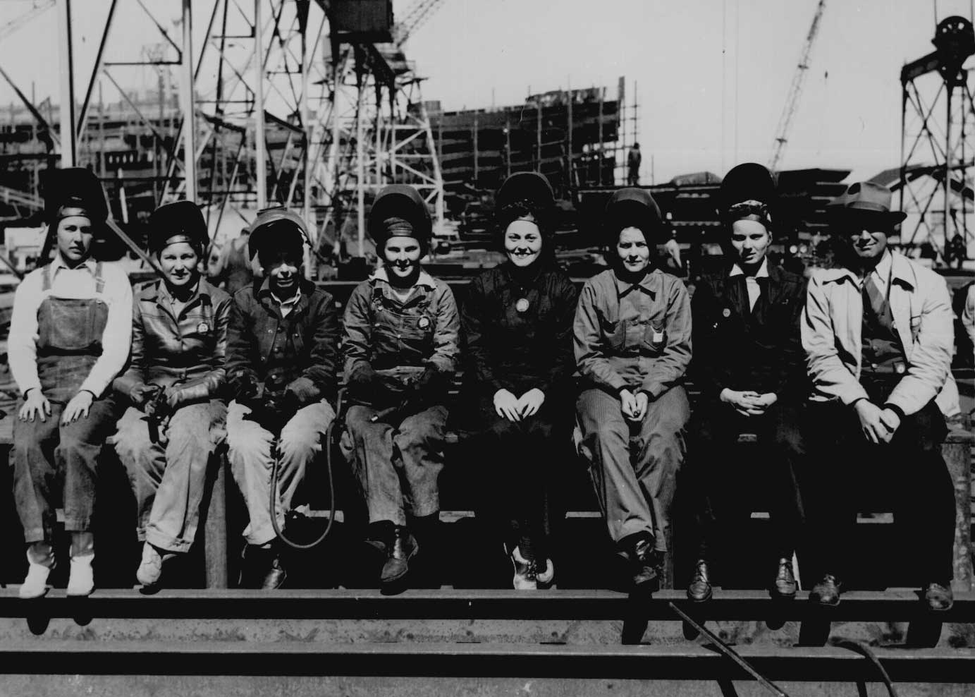 Historical photo of female welders sitting on a girder
