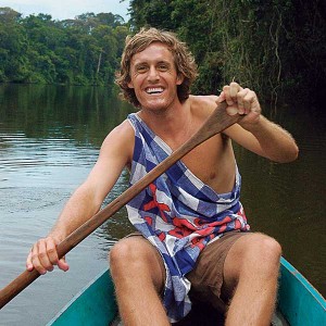 John Williams paddling a canoe while abroad with the Peace Corps