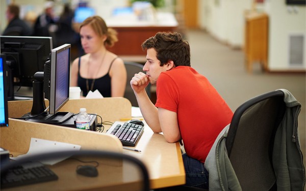 Student concentrating while working at a computer in Case Library
