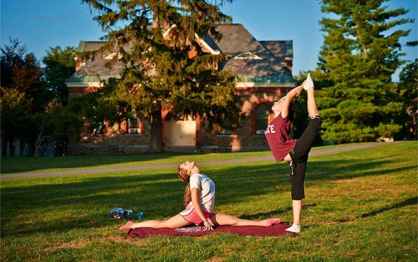 Two students practicing yoga on the academic quad