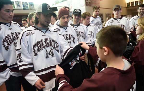 The hockey team in their jerseys meet their honorary coaches from Camp Good Days