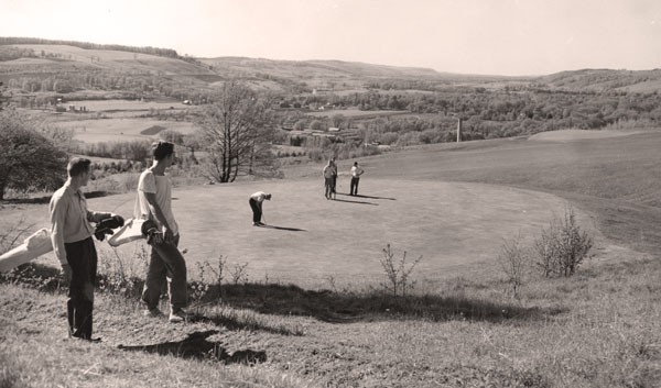 Archival black and white photo of golfers on a green