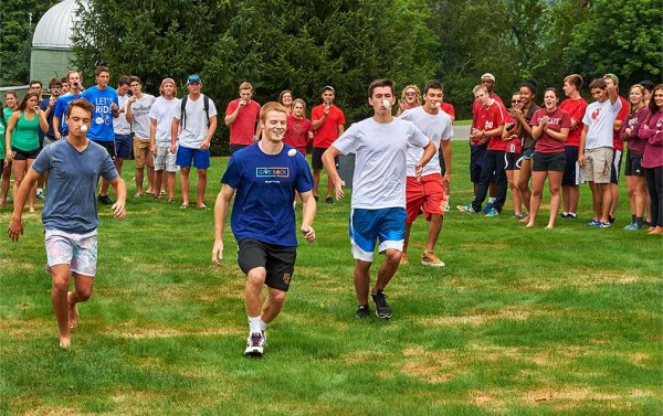 Students race while carrying an egg on a spoon in their mouths