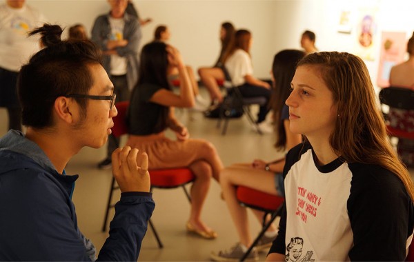 Artist speaks with a student at arts event