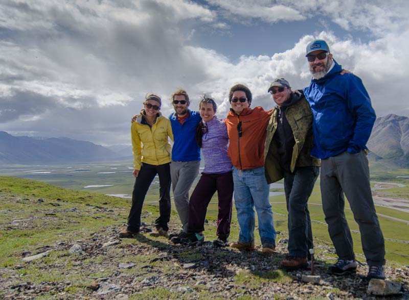 Research team in the field with mountains in the background