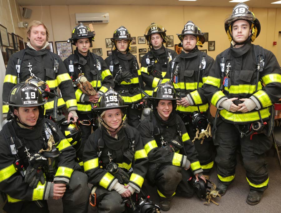 Firefighters pose for a photo in their gear at the station