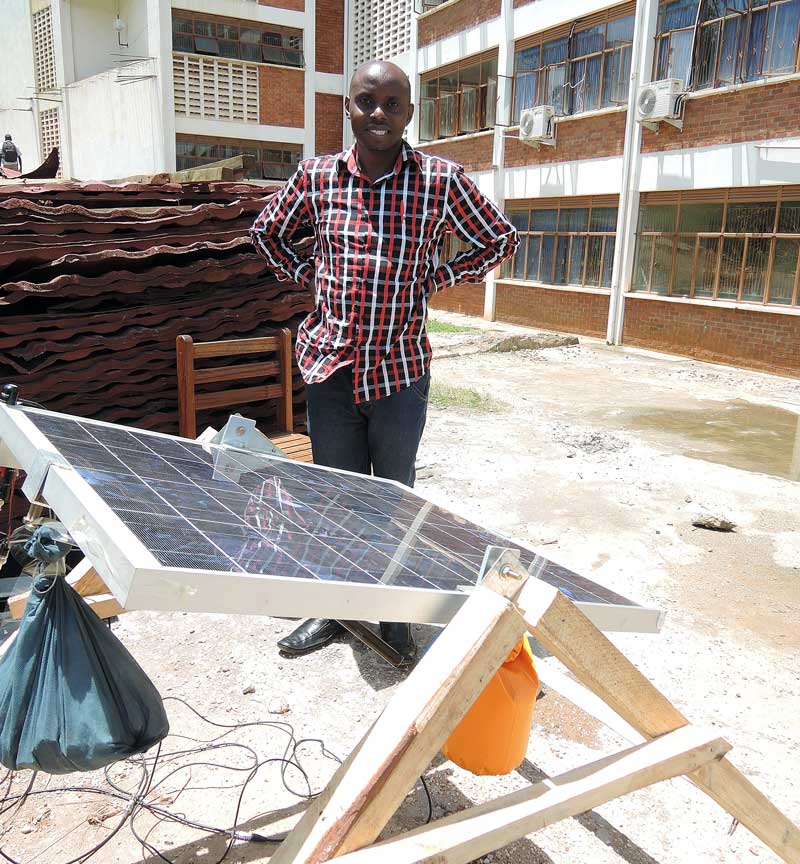 Lawrence Muzoora with a rotating solar panel