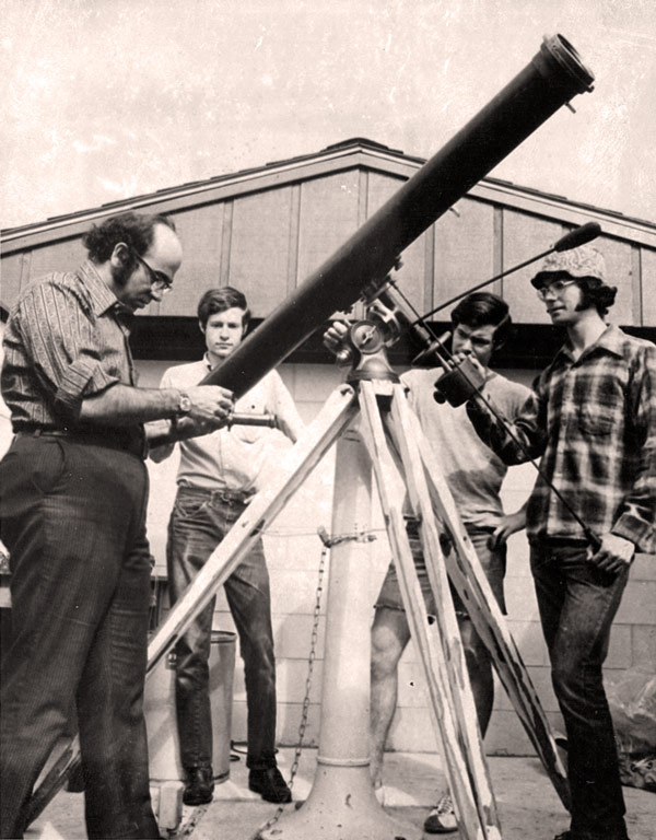 Tony Aveni prepares a telescope with three students in an old black and white photo