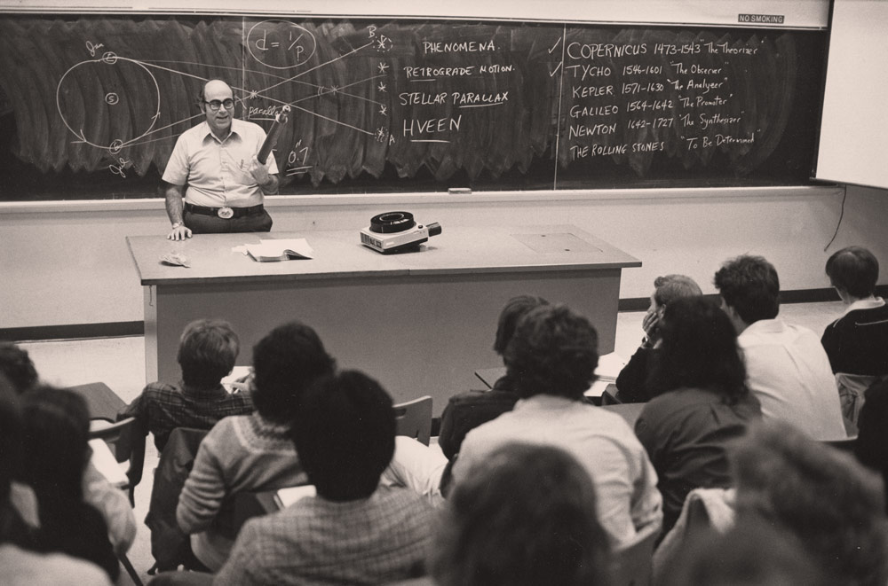 Tony Aveni lecturing a crowded classroom with a full blackboard behind him