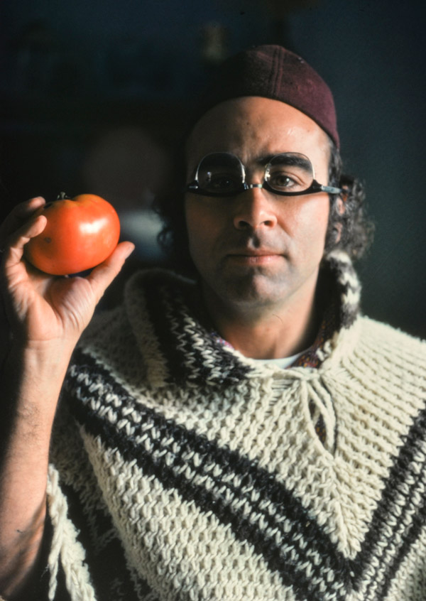 A young Tony Aveni holds up a tomato while wearing his glasses upside down