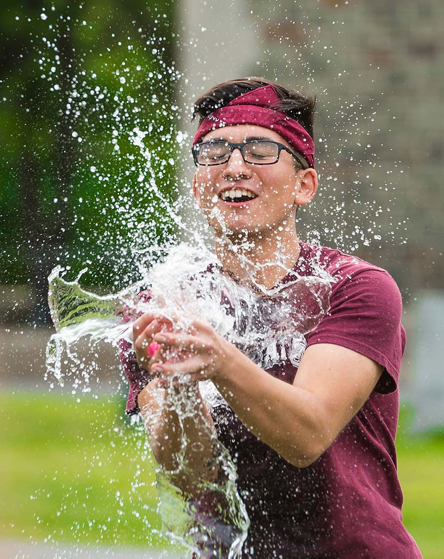 Water balloon breaks as student tries to catch it.