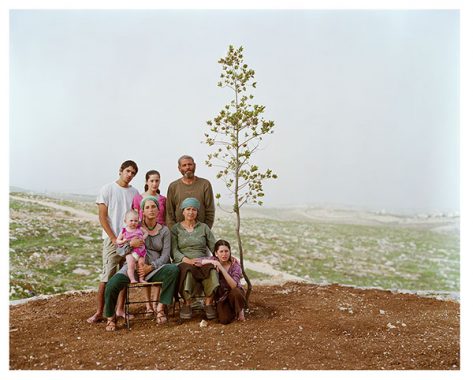 Family posing with sapling