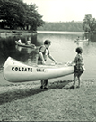 Two Colgate students launching a canoe