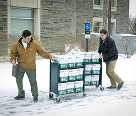 Cameron Borriello '14 and Michael Hendricks '14, two of four new co-owners of EcoCampus, deliver paper recently to Case Library.