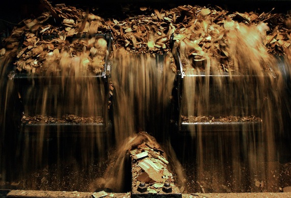 A stream of wood chips cascade into the “hopper,” the troth that feeds the firebox.
