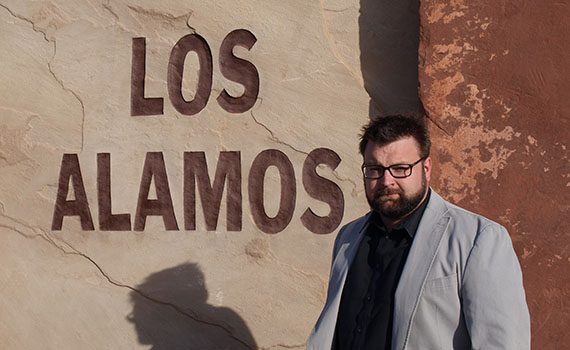Professor Jason Keith stands in front of the entrance to Los Alamos National Laboratory 
