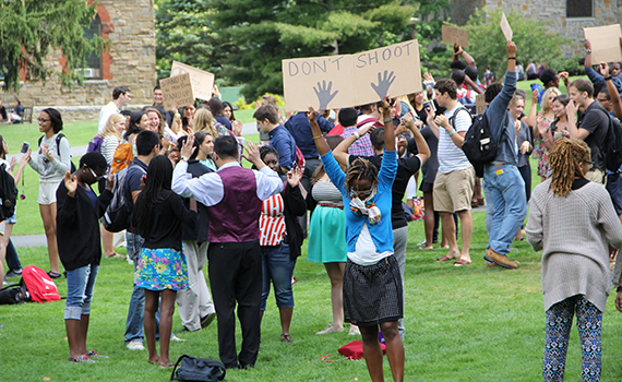 Colgate community members collectively put their hands up in a demonstration of their solidarity with Ferguson. Photo by Salote Tenisi '15