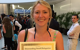 Kirsten Halvorson '15 shows a certificate for outstanding small delegation in Peru. 