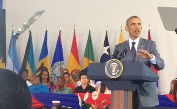 President Obama at a podium addressing a town hall event in Jamaica.