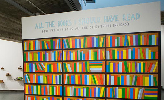 Work from Picker Gallery exhibition depicting painted bookshelf with title "All the books I should have read (but I've been doing all the other things instead)