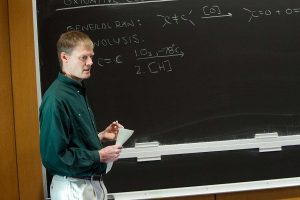 Professor Rick Geyer stands in front of chalkboard (Photo by Gerard Gaskin)