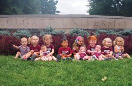 Babies lined up in front of Colgate sign
