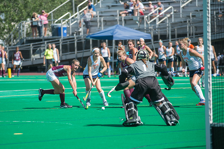 field hockey players attack the goal