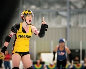 woman in roller derby gear pointing a finger confrontationally