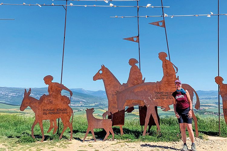 woman standing before copper sculptures of horses
