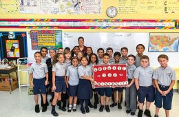 Fourth grade class holding up sign saying Colgate University 200