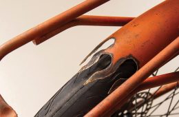 Close up of a rusty orange bike with flame details