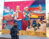 Muralist before his mural of Mexican folk musicians