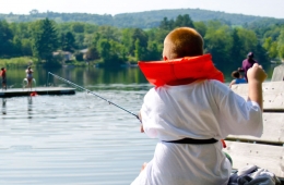 camper wearing life jacket goes fishing