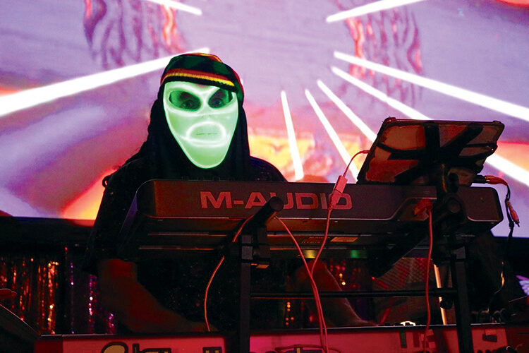 Casual Alien on stage in a neon green alien mask