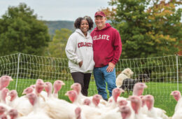Marc and Susan Jaffe standing on their farm behind turkeys