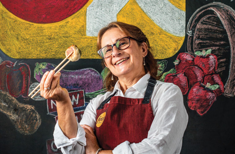 Miriam Garron ’83 standing in front of chalk art Food Network logo