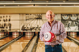Dale Schwartz ’83 holding a bowling ball in a bowling alley.