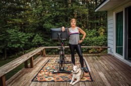 Nicole St.Jean ’98 with exercise bike and dog on deck