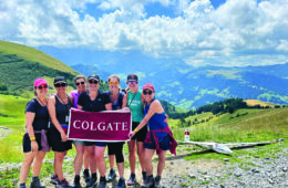 Group of alumna hold Colgate banner on mountain summit