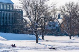 Students sledding in front of James C. Colgate Hall