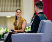Misty Copeland with microphone in hand sits in a chair on the Memorial Chapel stage