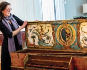 Christina Linsenmeyer opens the cover of an antique harpsichord
