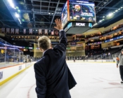 Hockey coach Don Vaughan waving to arena