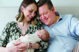 Two parents hold their newborn